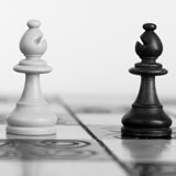 black and white chess pieces facing each other