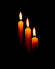 three candles against a dark background