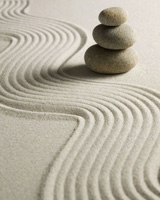 rock garden: sand raked in wavy pattern and cairn with 3 stones