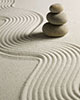 rock garden: sand raked in wavy pattern and cairn with 3 stones